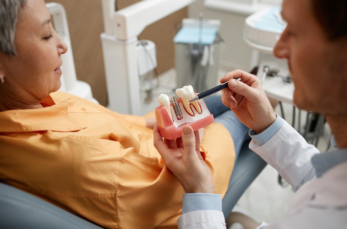 dentysta pokazuje implanty zębowe